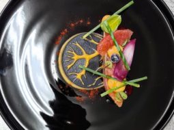 Piatto nero con salmone, frutta e verdura